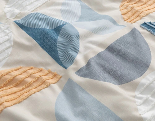 Close-up on the tufted appliqué and half-moon designs over the surface of our Nora Duvet Cover.