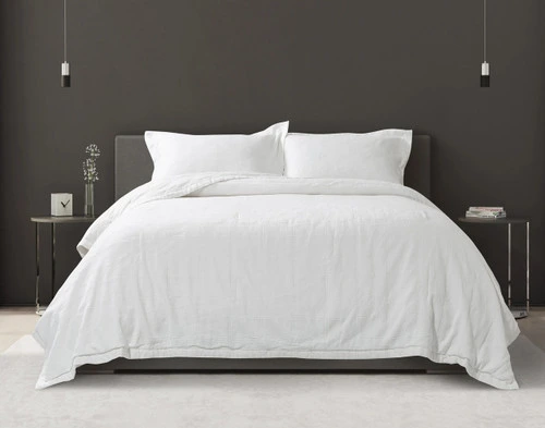 Front view of our luxurious Shelby Quilt Set dressed over a queen bed in a dark modern bedroom.