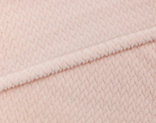 Close-up on the hemmed border on our Chevron Plush Throw in Blush to show its matching reverse and front together.