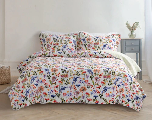 Front view of our Maxine Floral Cotton Quilt Set over a queen bed in a white bedroom.