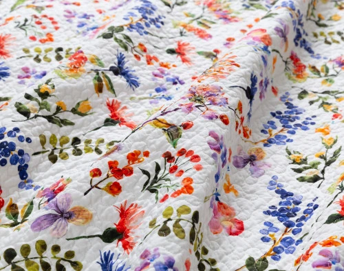 Close-up on the vibrant floral design on the surface of our Maxine Floral Cotton Quilt Set.