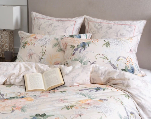 Angled view of our Cabana Pillow Shams resting on a matching bed with an open book over the duvet cover.