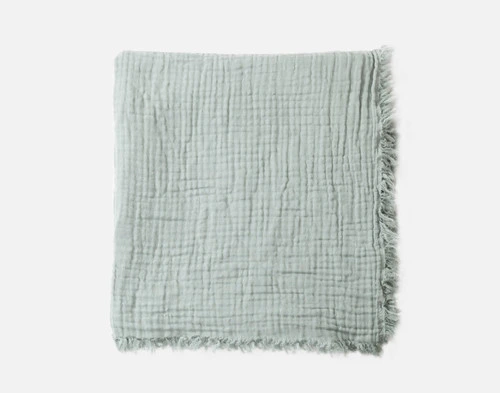 Top view of our Muslin Gauze Throw in Seagrass folded into a tidy square.