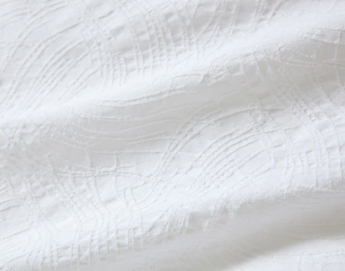 Close-up view of the textured white surface of our Corvo Duvet Cover.