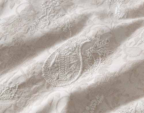 Close-up on an embroidered paisley teardrop design on the surface of our Prescott Duvet Cover.