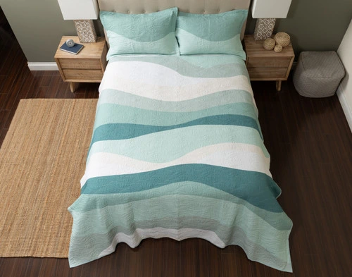 Top view of our Ocean Waves Cotton Quilt Set to show its mixed green, teal, and white waves.