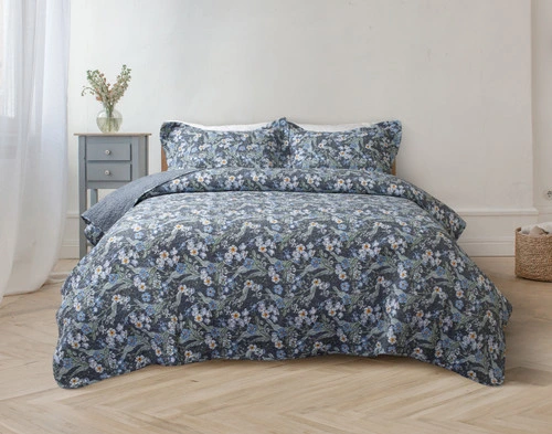 Front view of our Cornflower Cotton Quilt Set dressed over a queen bed in a minimalist white bedroom.