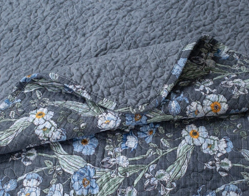 Close-up of the folded corner on our Cornflower Cotton Quilt Set to show its surface and reverse patterns together.