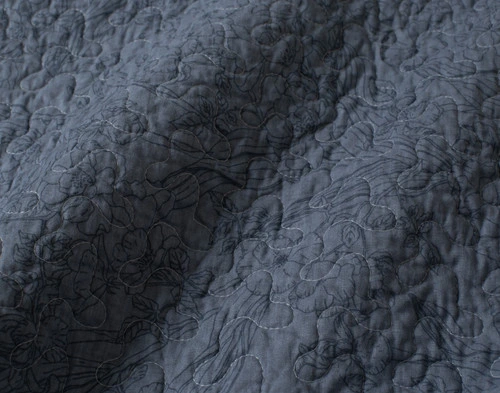 Close-up on the subtle floral outlines on the backing of our Cornflower Cotton Quilt Set.