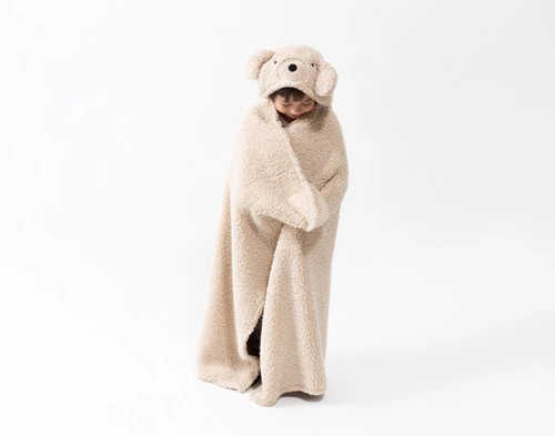 Front view of a school-aged child wearing our Bear Hooded Animal Throw in a plain white room.