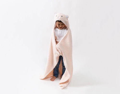 Front view of a school-aged child wearing our Kitten Hooded Animal Throw in a plain white room.