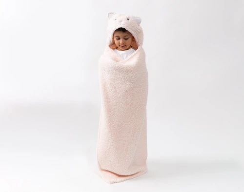 Front view of a school-aged child wrapped up in our Kitten Hooded Animal Throw in a plain white room.