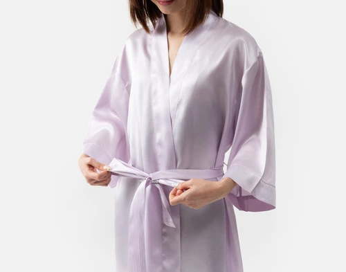 Close-up of our Lavender Silk Kimono Robe being worn by a young woman adjusting the coordinating belt.