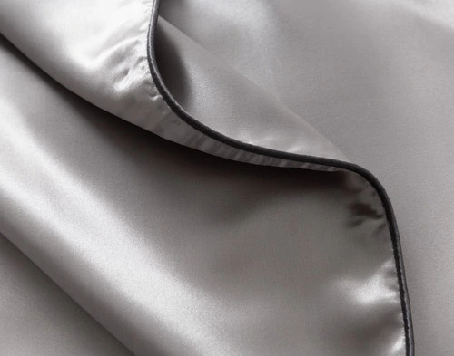 Close-up on the dark grey piped edge on our Silver Mulberry Silk Piped Edge Pillow Sham.