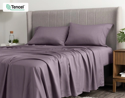 Angled view of our BeechBliss TENCEL™ Modal Sheet Set in Purple Haze draped casually over a queen bed with no duvet cover or coordinating accessories.