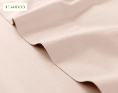 Flat sheet for our Bamboo Cotton Sheet Set in Rosemist ruffled lightly over a matching smooth surface.