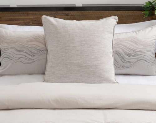 Front view of our Striation Euro Sham sitting on a tidy white bed with coordinating pillow shams.