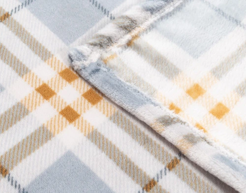 Close-up of the soft fleece surface and plaid pattern on the corner of our Forbes Plaid Throw.