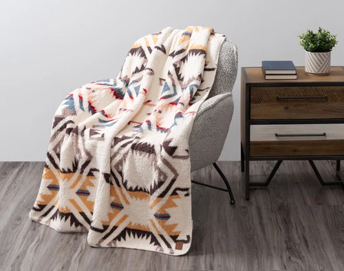 Angled view of our Natural Southwest Throw draped over a small grey armchair.