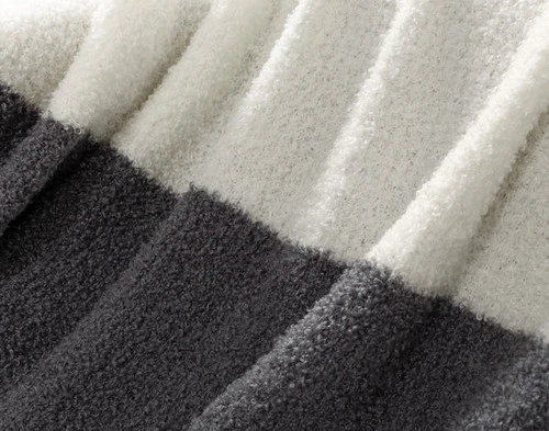 Close-up of the knit surface and alternating colours of our Grey & Cream Wooly Knit Throw.