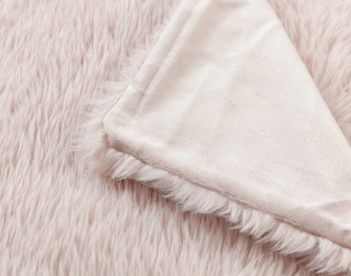 Top view of our Pink Soft Mink Throw folded into a tidy square in a white room.