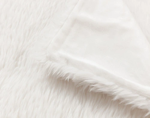 Top view of our White Soft Mink Throw folded into a tidy square in a white room.