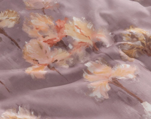 Close-up view of the apricot and blush florals on the surface design of our Irisette Duvet Cover.