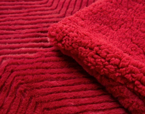 Close-up on the folded corner of our Ruby Red Chevron Etch Throw.