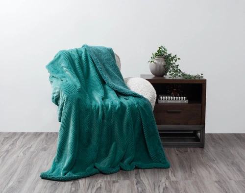 Front view of our Deep Sea Chevron Etch Throw draped over a small chair in a simple living room.