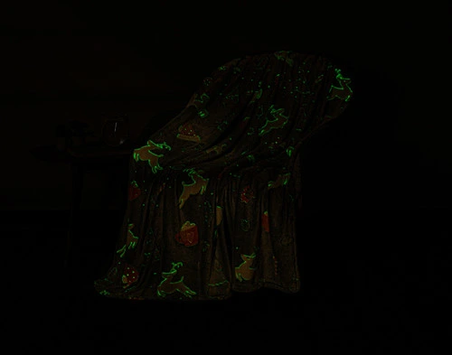 Dark view of our Sweet Treats Glow in the Dark Fleece Throw to show its pattern glowing in a soft green.