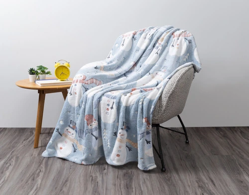 Our Frosty Glow in the Dark Fleece Throw draped over an armchair in an empty grey living room.