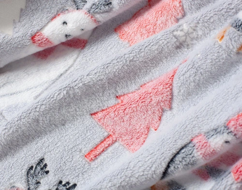 Close-up on our Polar Festivities Glow in the Dark Fleece Throw to show its playful holiday-friendly design.