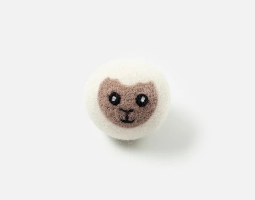 Front view of our Lambert Embroidered Wool Dryer Ball sitting on a solid white surface.