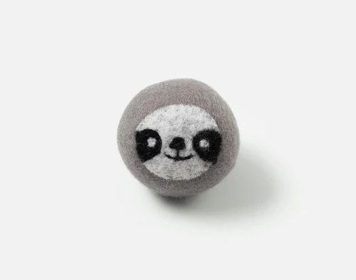 Front view of our Paula Embroidered Wool Dryer Ball sitting on a solid white surface.