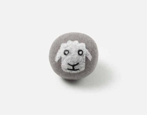 Front view of our Sherman Embroidered Wool Dryer Ball sitting on a solid white surface.