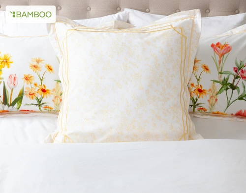 The Corsage Euro Sham dressing the head of a bed along with the Corsage Pillow Shams.