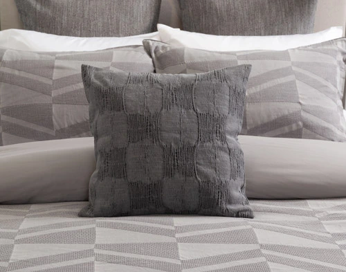 Our Mazama Square Cushion Cover resting on its coordinating duvet cover.