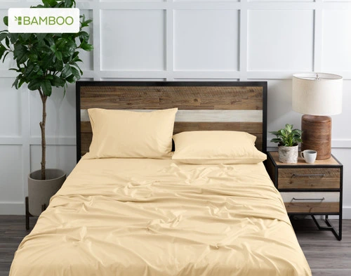 Top view of our Bamboo Cotton Sheet Set in Huckleberry, dressed over a wooden bed in a white plant-filled bedroom.