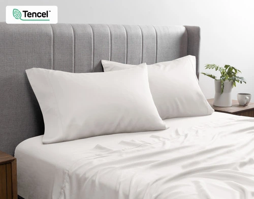 Front view of our BeechBliss TENCEL™ Modal Pillowcase in Moon resting against a headboard in a bed with matching sheets.