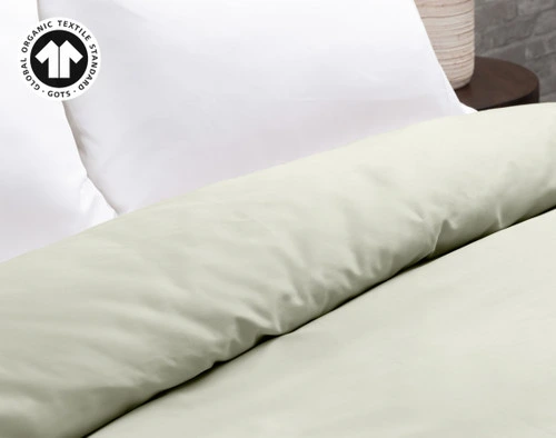 Our Organic Cotton Duvet Cover in Sagebrush Green at the head of a bed with white pillows.