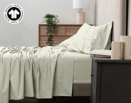 Side view of our Organic Cotton Sheet Set in Sagebrush to show its flat sheet draped over the side.