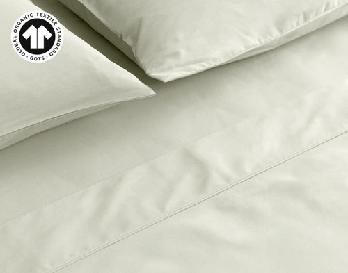 Close-up on our Organic Cotton Sheet Set in Sagebrush to show its pillows, flat sheet, and fitted sheet neatly made.