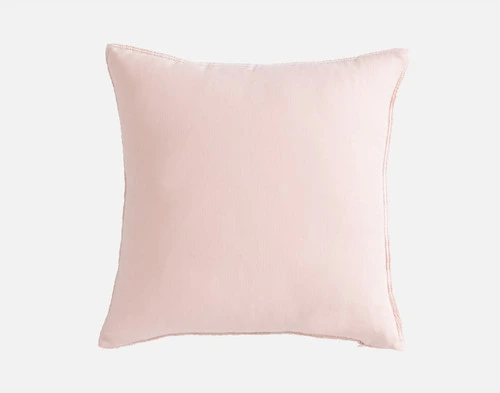 Back view of our Crinkle Square Cushion Cover in Peony sitting in front of a solid white backdrop.