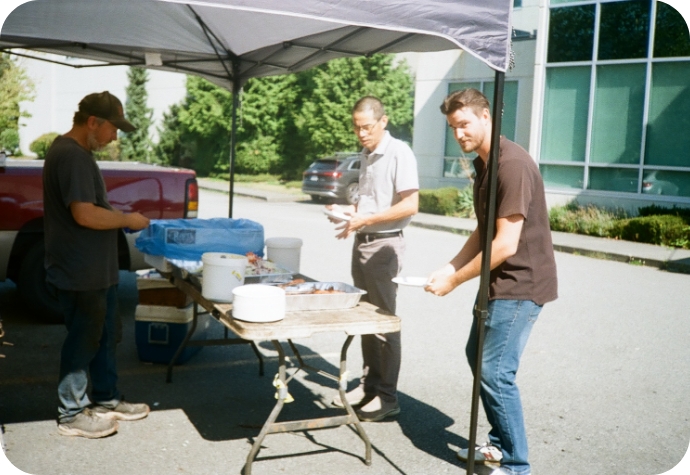 Our Sustainability Manager stands in line for the barbecue lunch, facing the camera as they wait their turn.