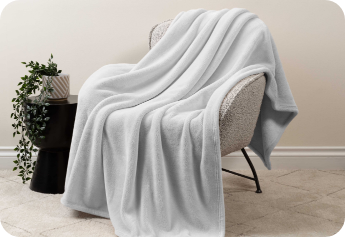 A plush velvet throw blanket draped over a chair.
