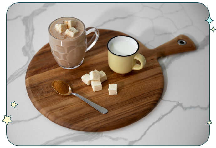 Angled view of a sleepy time hot chocolate drink, with its ingredients plated on a round wooden tray.