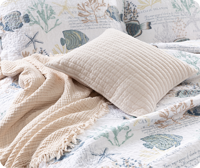 Our Marella Cotton Quilt Set styled with our Muslin Gauze Throw in Natural and Linen Cotton Square Cushion Cover in Flax